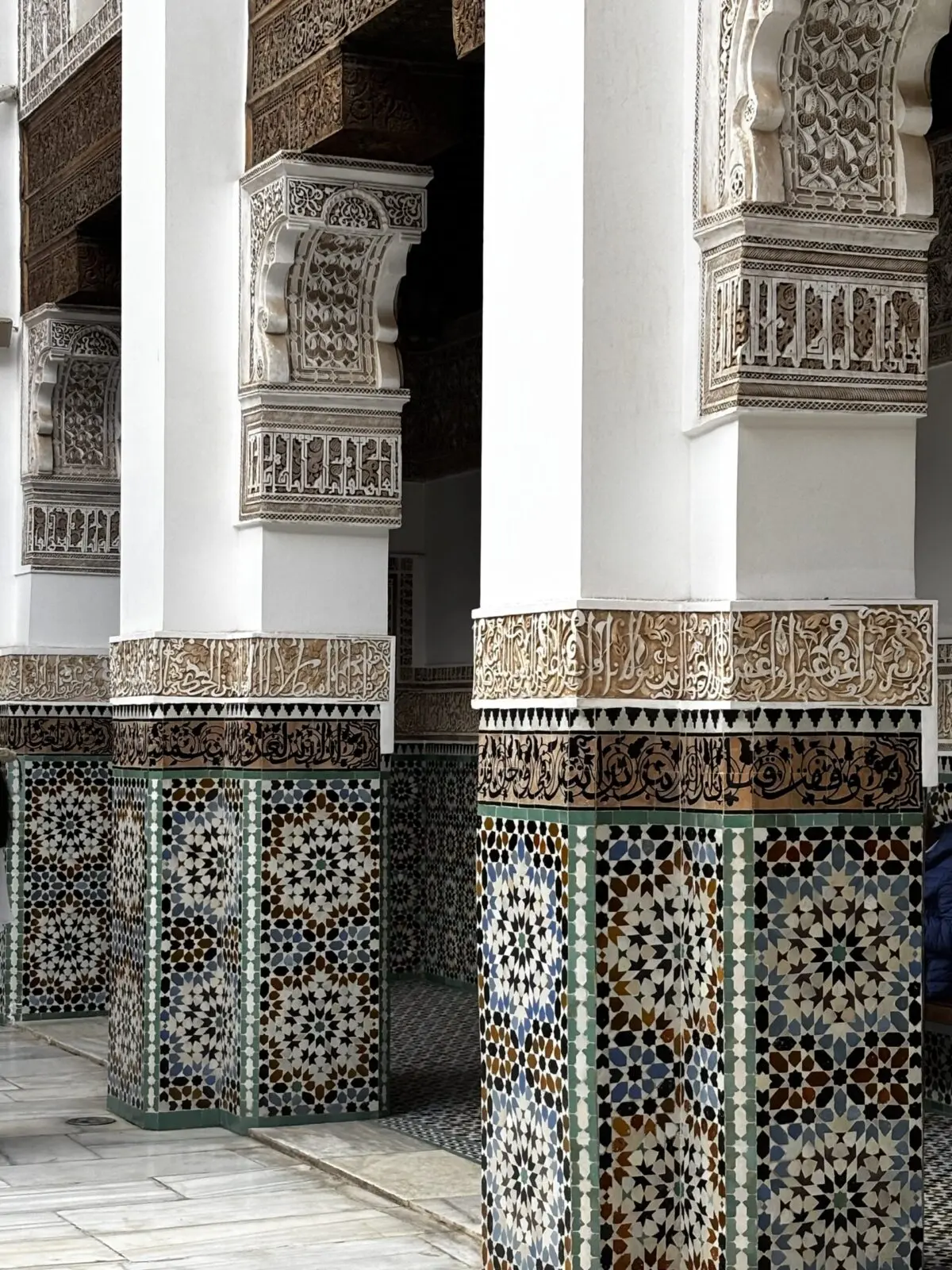 Tiled columns with intricate carving in Madrasa Ben Youssef seen during our two days in Marrakech
