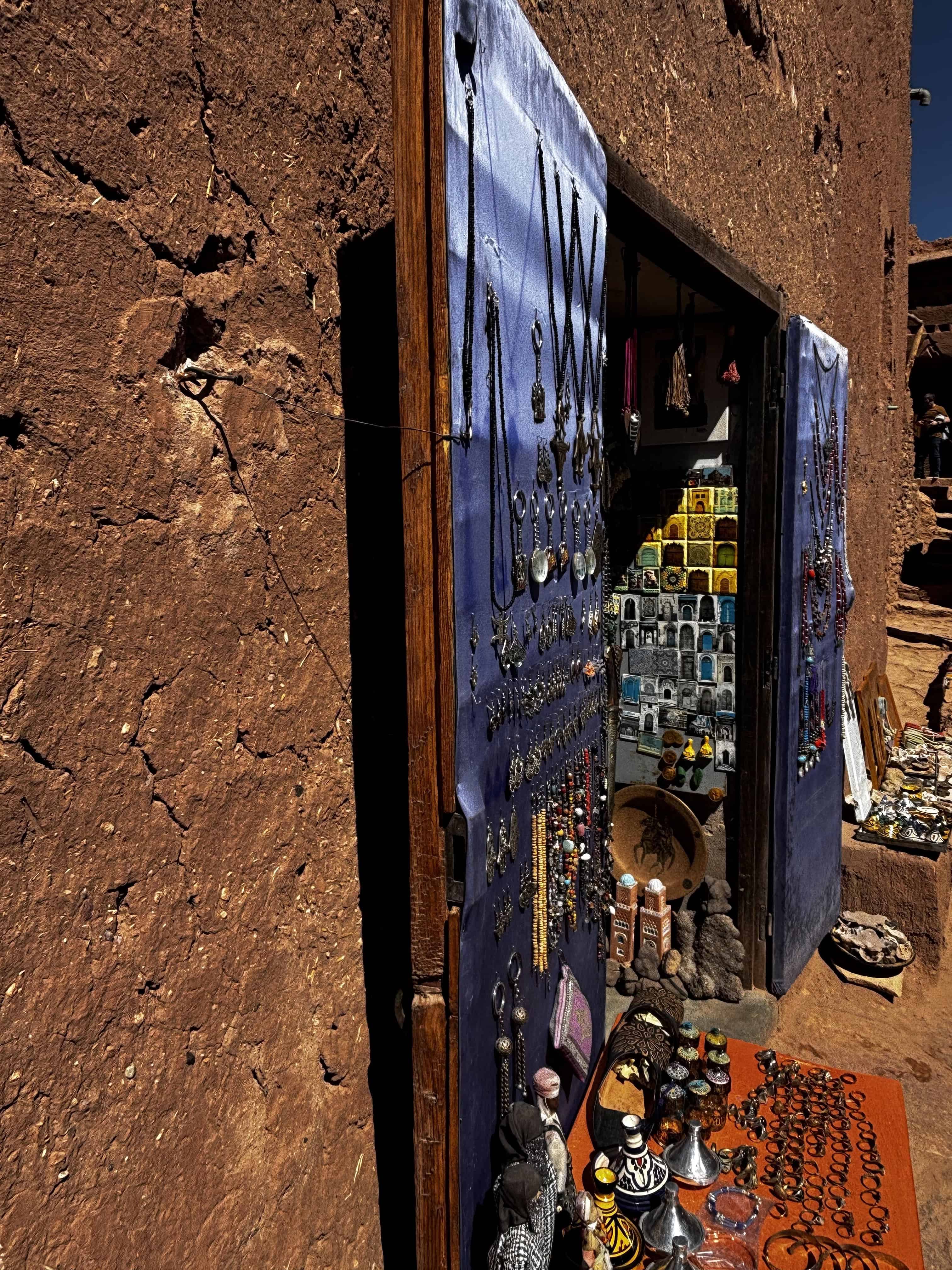 Vibrant roadside market stall selling jewellery and souvenirs in a desert setting.