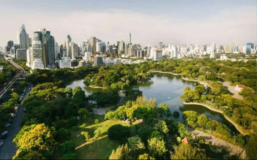 Green park with highrise buildings of Bangkok in the distance.