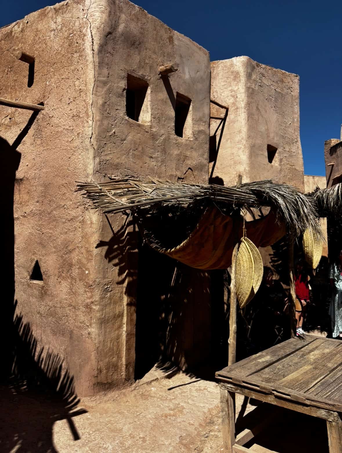 Traditional desert village, mud houses, straw accents, ancient architecture.