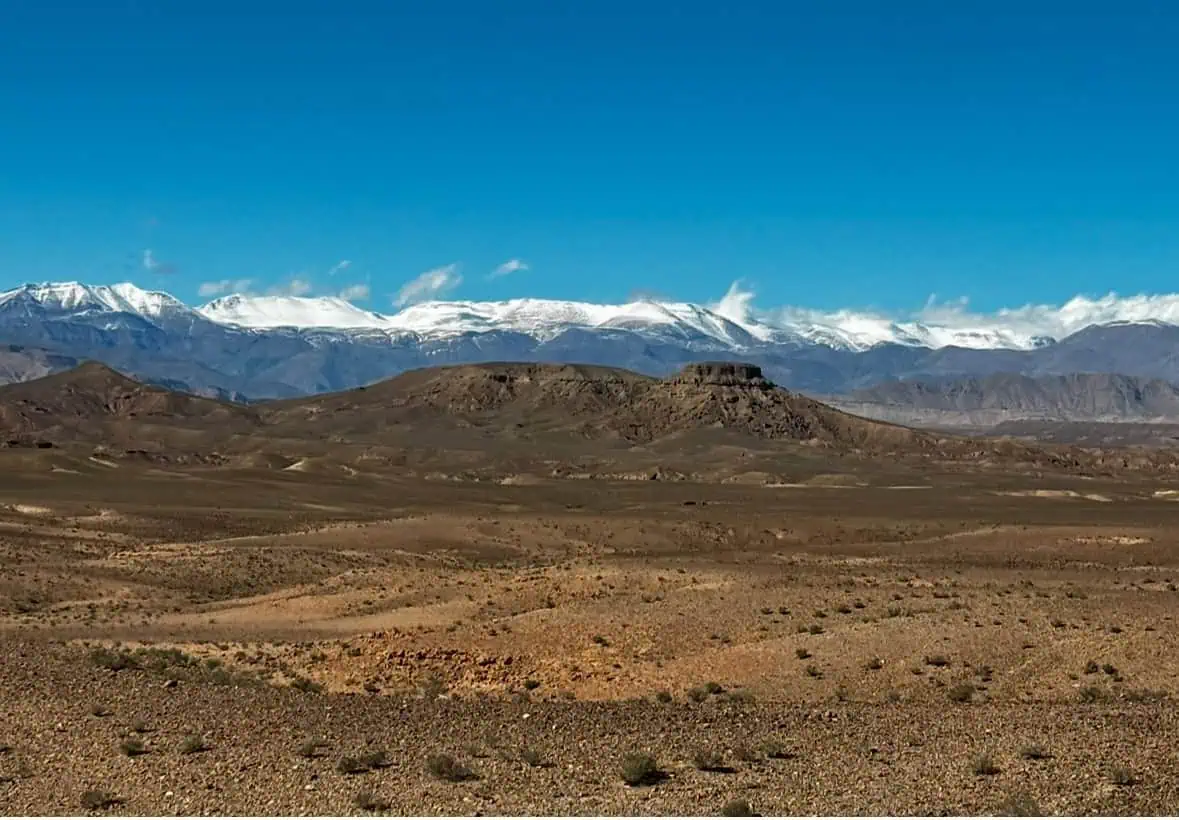Scenic desert view with distant snow-covered mountains, perfect for travel stories and adventure.