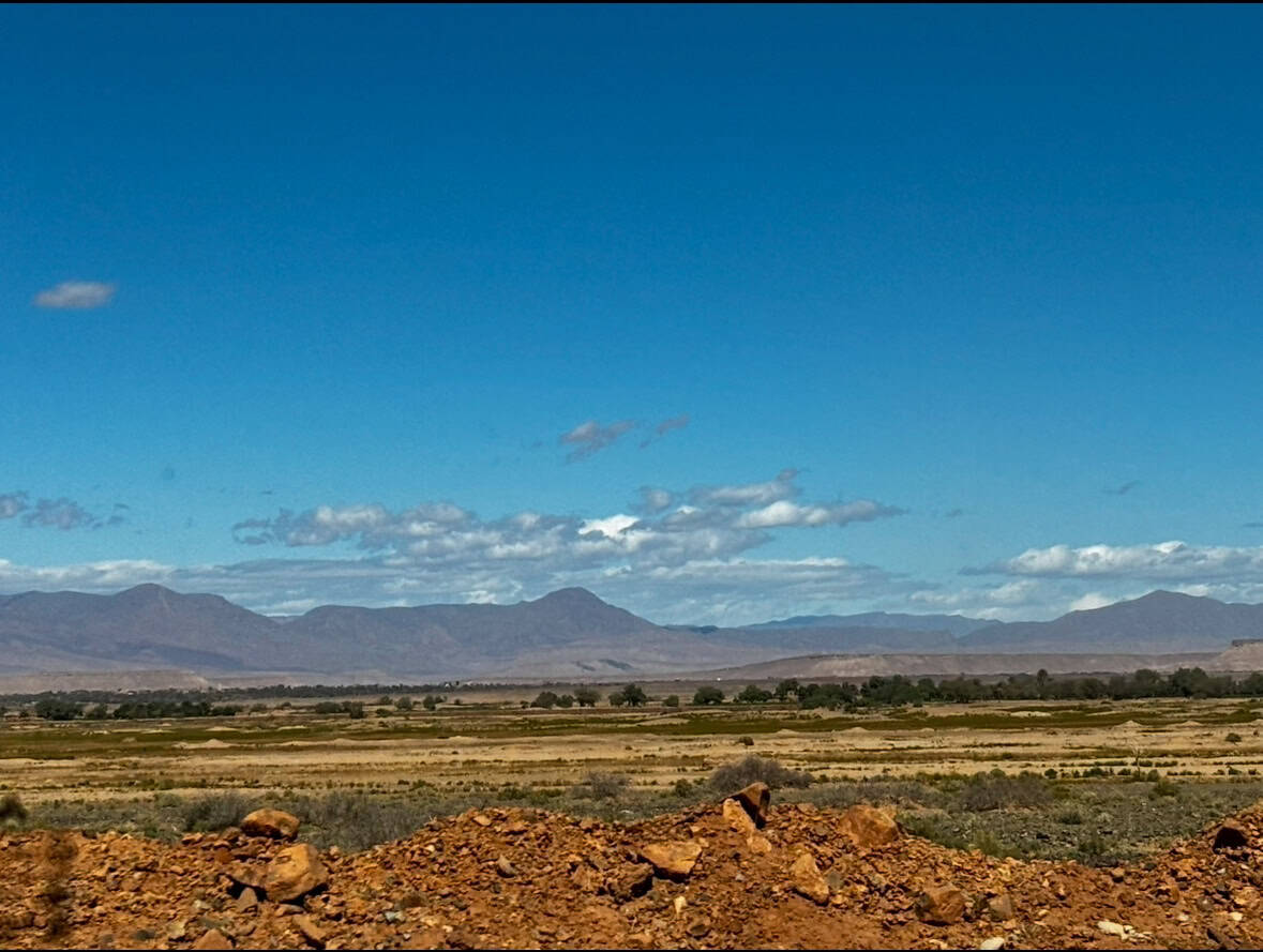 Vast Australian desert with mountains and open skies, ideal for travel adventures and road trip content.