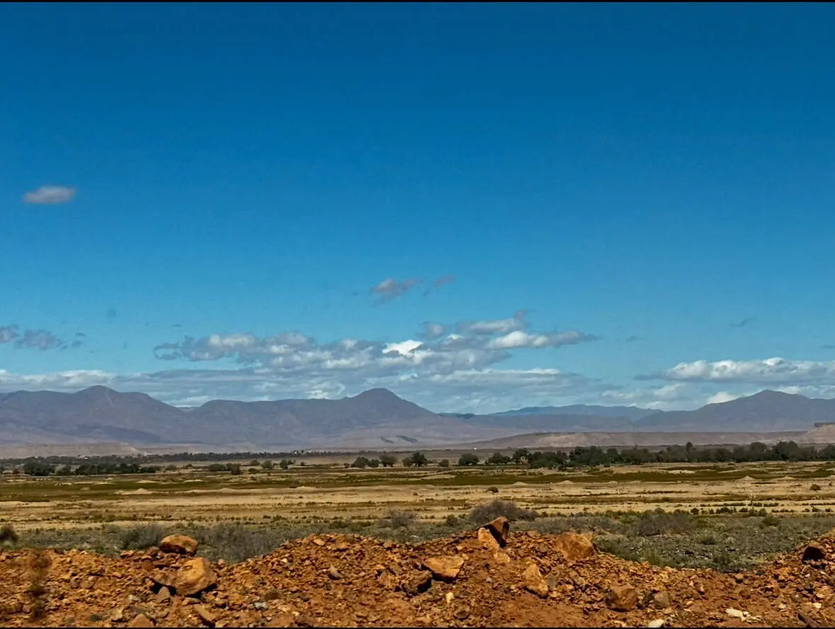 Vast desert with mountains and open skies, ideal for travel adventures and road trip content.
