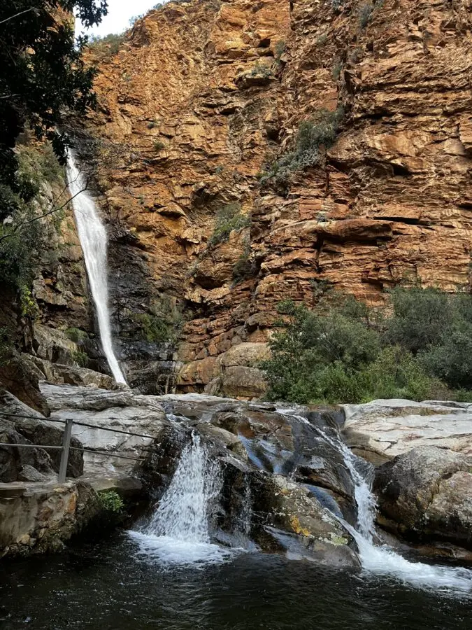 Meiringspoort waterfall coming down the mountain between ochre rocks.