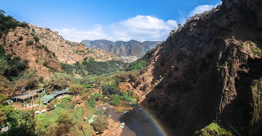 Beautiful canyon landscape with river and rainbow under clear blue sky, perfect for summer travel imagery.Seen on a tour from Marrakech.