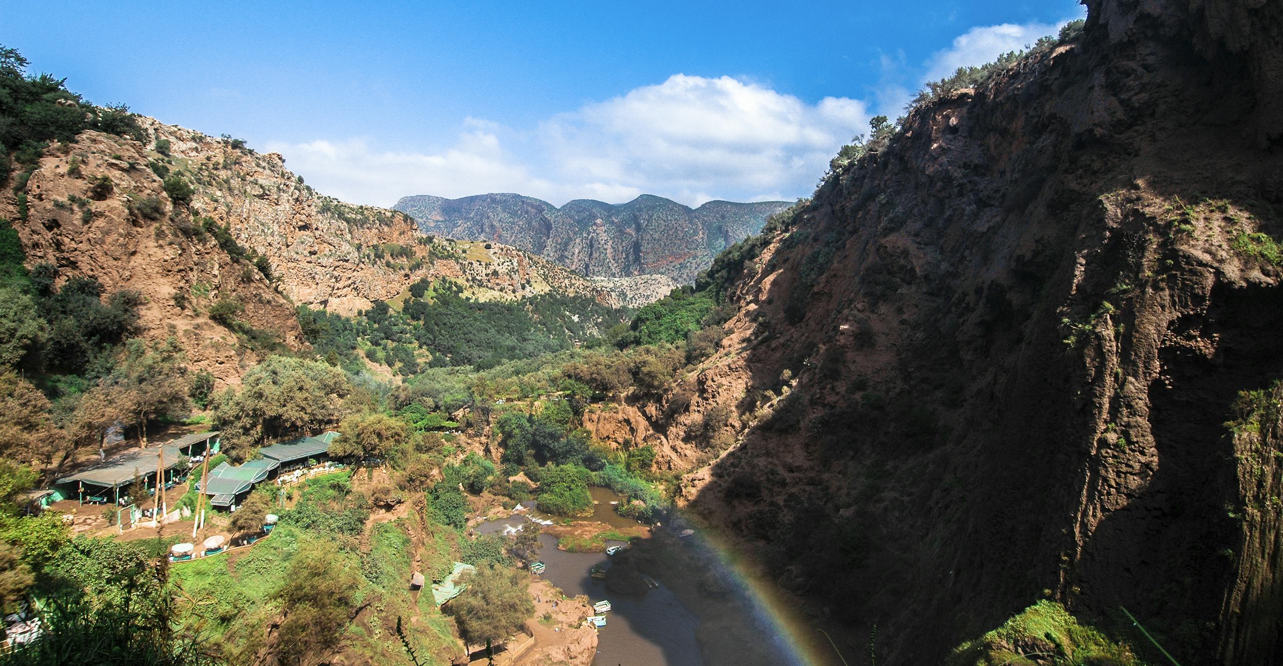 Beautiful canyon landscape with river and rainbow under clear blue sky, perfect for summer travel imagery.