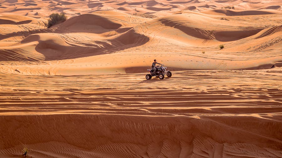 Experience thrilling quad biking over expansive desert dunes under the bright sun on a tour from Marrakech