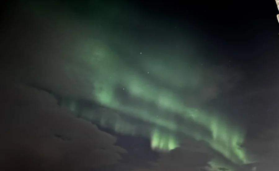 Green aurora in a partly clouded sky, Iceland
