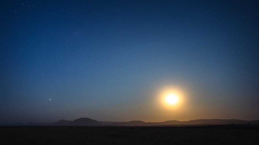 Breathtaking night sky in Iceland featuring a full moon illuminating the serene landscape.