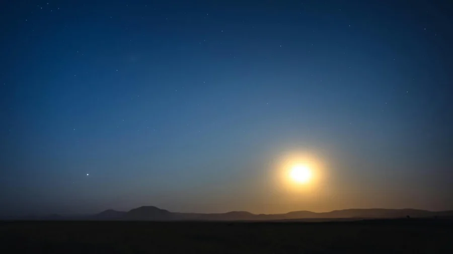 Breathtaking night sky in Iceland featuring a full moon illuminating the serene landscape.