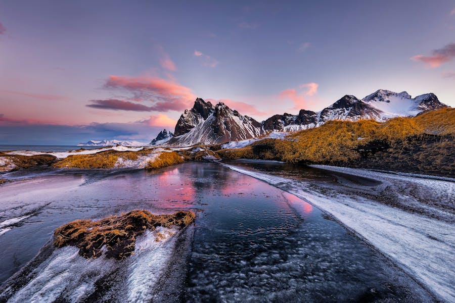 Vestrahorn mountains with frozen lake at sunset, stunning natural landscape.