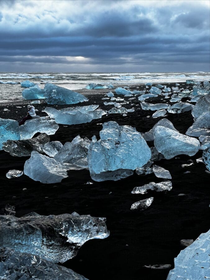Blue and silvery chunks of ice on black sand, sparkling like diamonds. Diamond Beach, Iceland