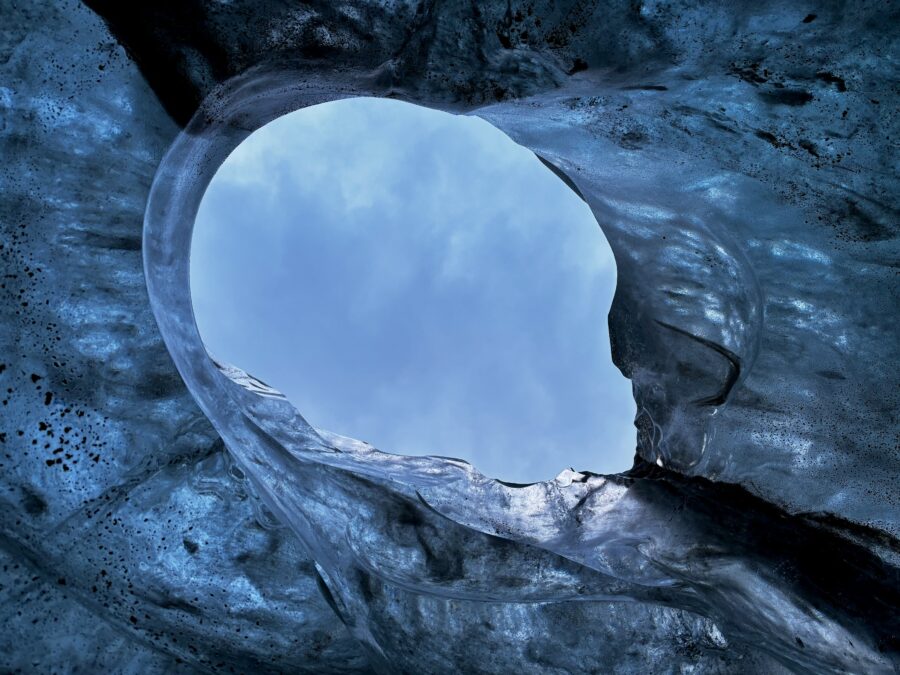 The sky seen through a hole in a blue ice cave, part of Vattnajökull glacier, Iceland
