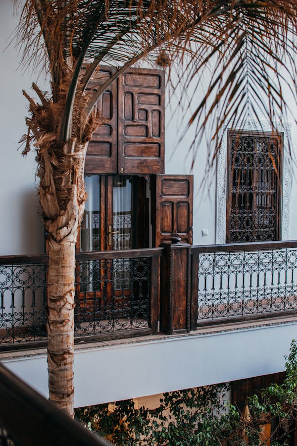 Capture of a traditional Moroccan balcony with ornate doors in Marrakesh.