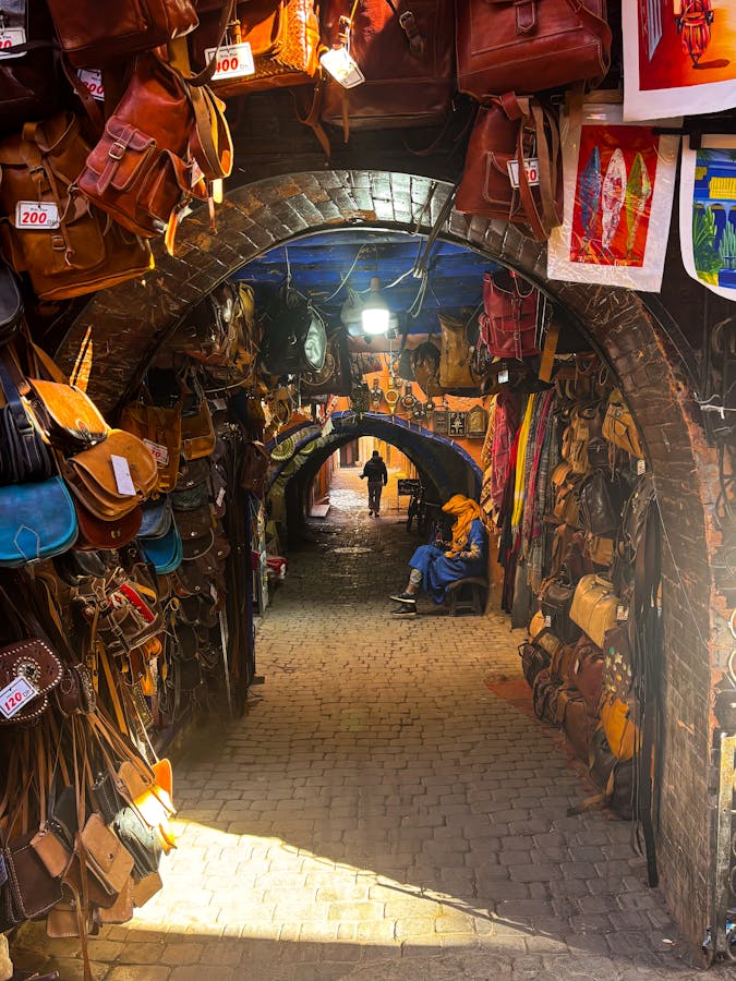 Explore the bustling souks of Marrakech's Medina with colorful bags and crafts.