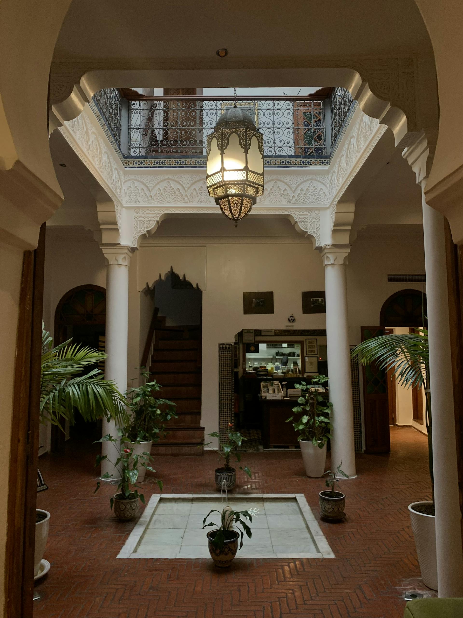Stunning interior of a Moroccan riad with traditional architecture and lush greenery.