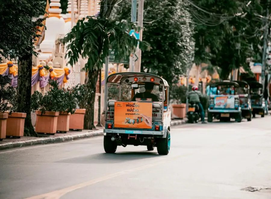 Vibrant Bangkok street filled with colorful tuk tuks showcasing urban transportation in Thailand. 