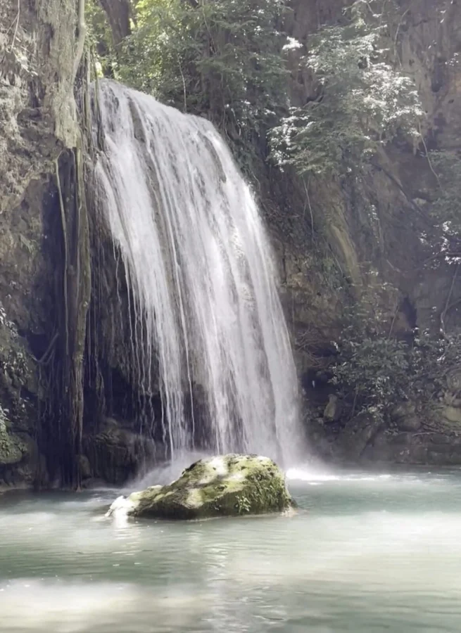 Level three at Erawan Falls in Kanchanaburi Province, Thailand. A high waterfall falling into a pool from some height.
