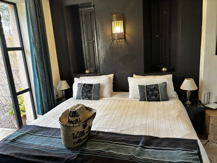 Photo: Tales From The Road Ahead. Bedroom of garden cottage at Villa Dinari, Marrakech. Freshly made bed, blue and white, comfortable-looking.