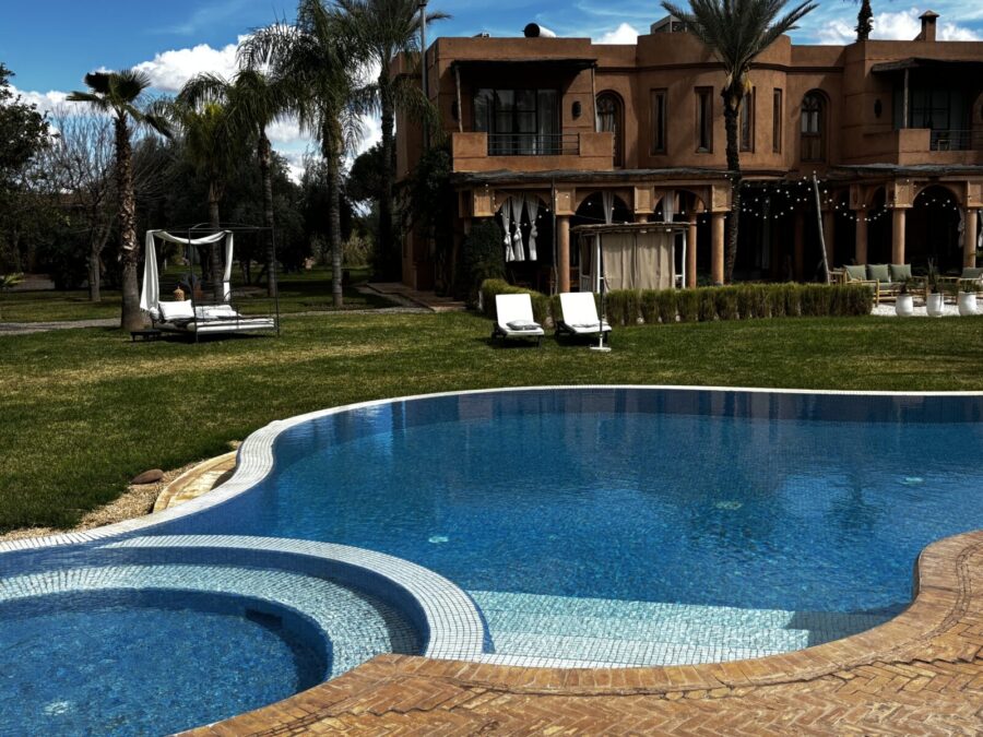Photo: Tales From The Road Ahead. Blue swimmingpool. Lawn, sun beds and Villa Dinari in the background.