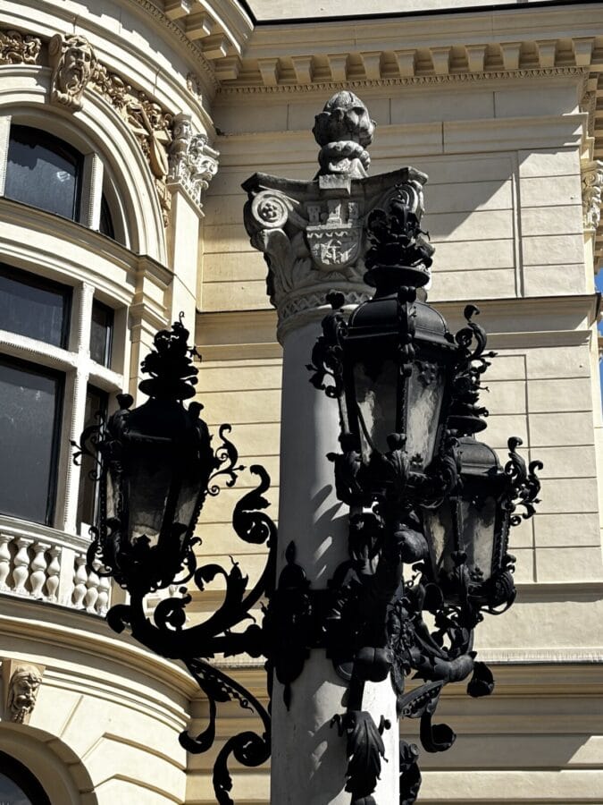 Photo: Tales From The Road Ahead. Lantern with intricate detail in cast iron. Seen against a beautifully decorated sand-coloured building on Rynek Główny, Kraków - the main square. 