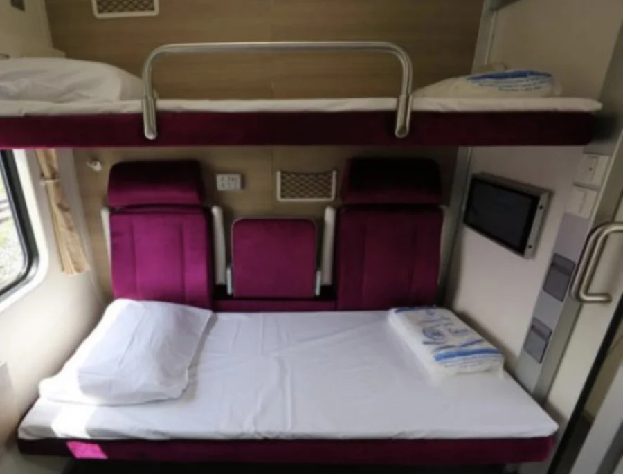 First class carriage on the sleeper train from Chiang Mai to Bangkok. Bed is made, light outside.