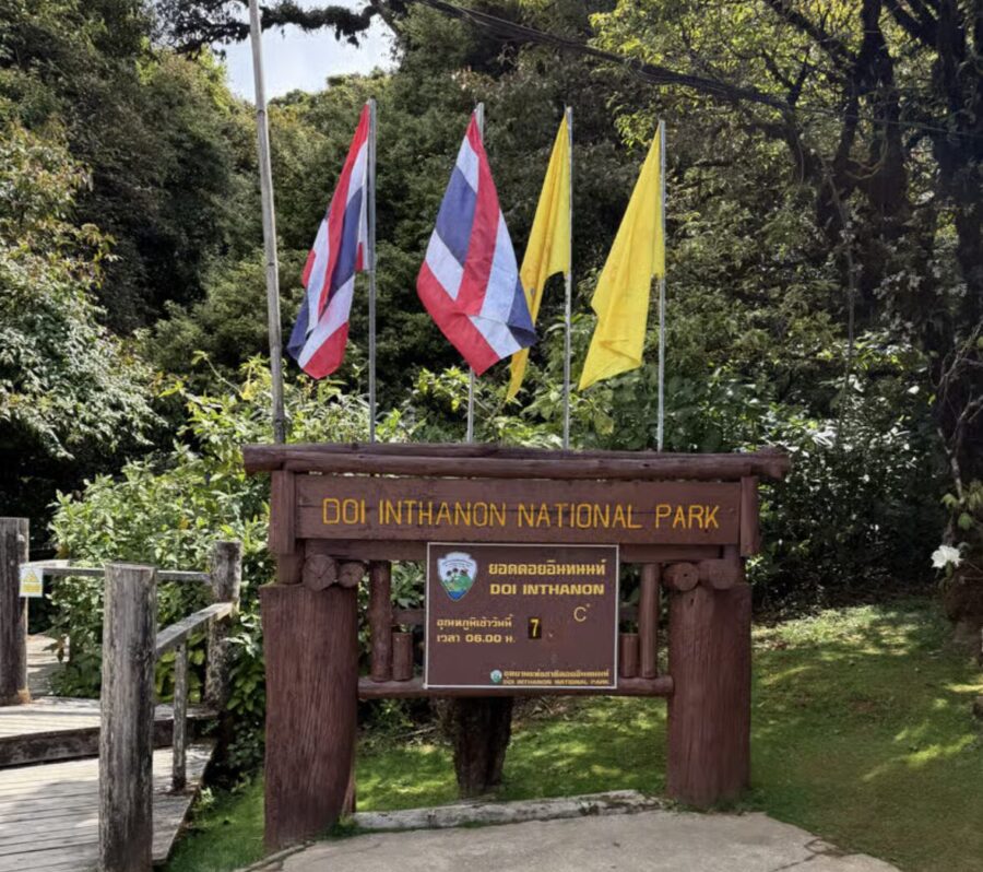 Entrance to Doi Inthanon National Park: wooden sign with flags 
