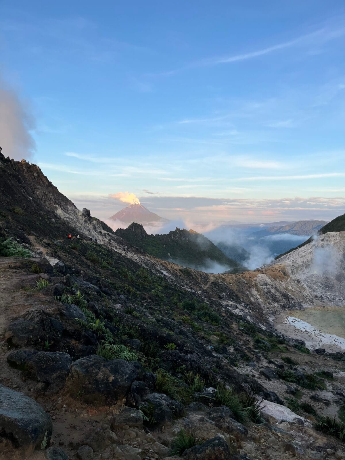 Photo Talesfromtheroadahead. View from the top of Sibayak volcano, Sumatra. Steam rising from steam vents, smoke rising from Sinabung in the background