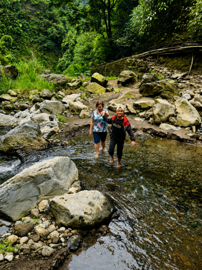 Photo Talesfromtheroadahead. Woman crossing river near Madakaripura Falls East Java
